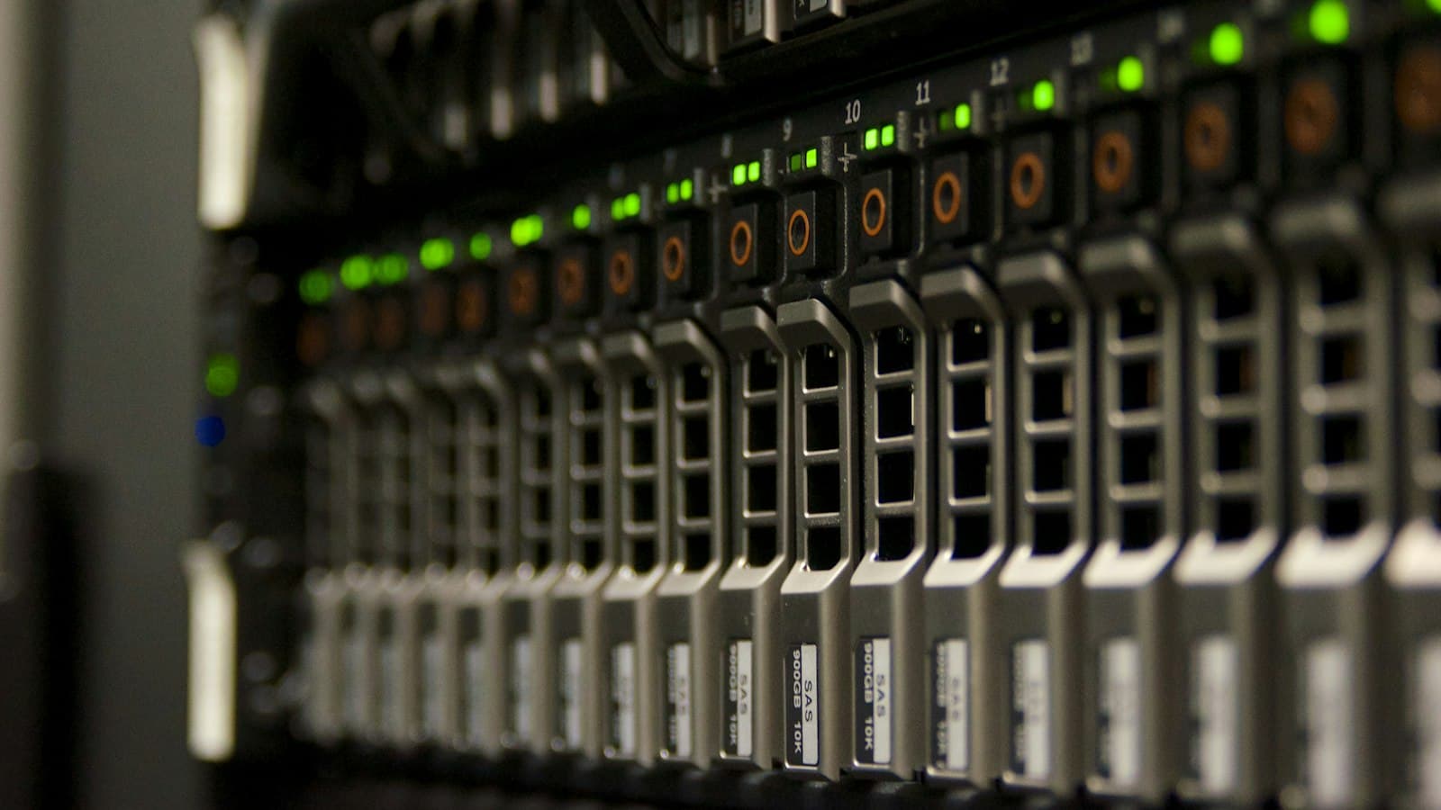 A server rack in a data center, its rows of drive bays lit by green status lights